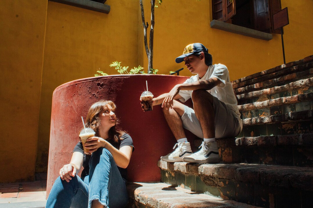 Two Brazilian colleagues having a warm, supportive conversation outdoors